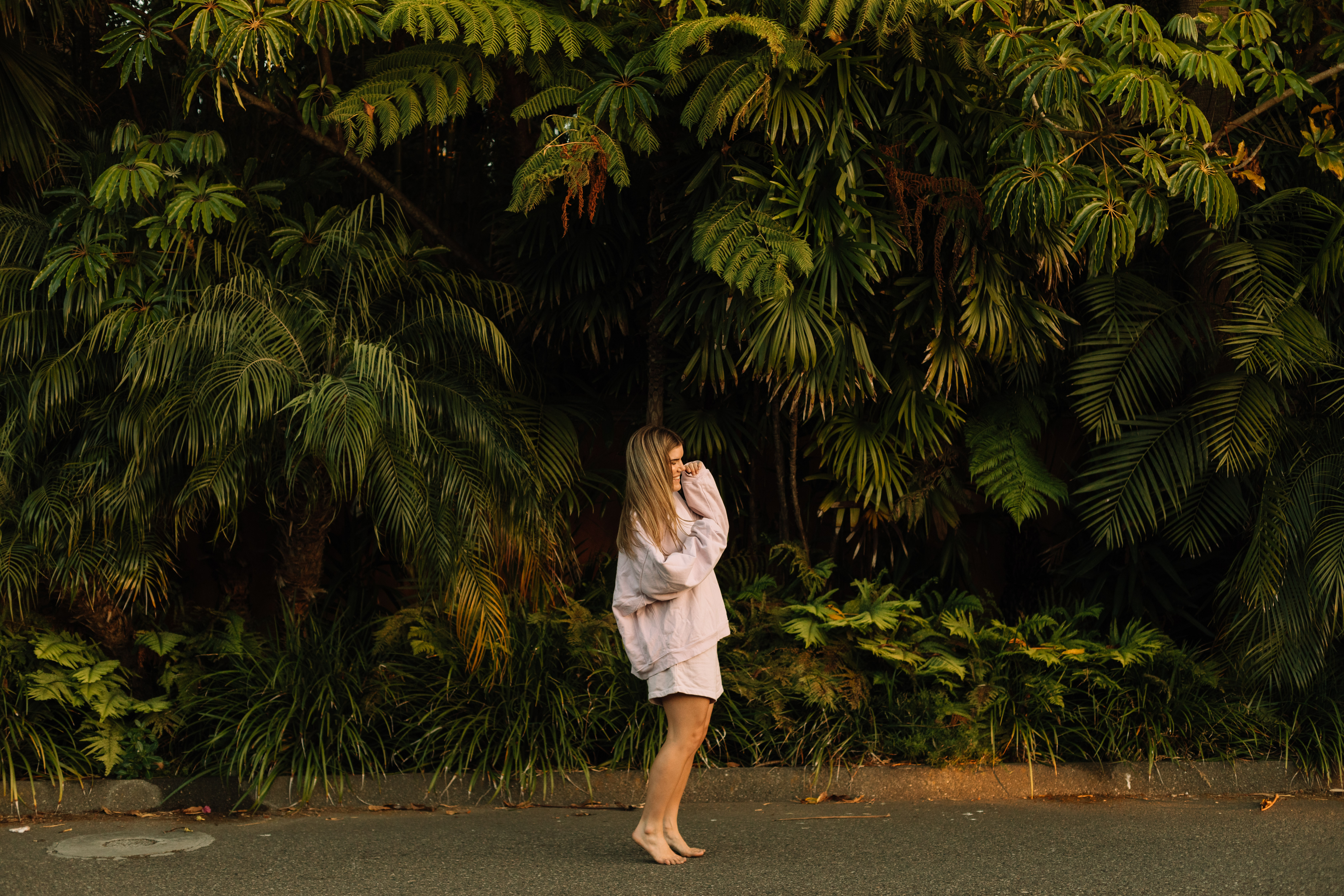 Cambria Joy standing barefoot among the ferns